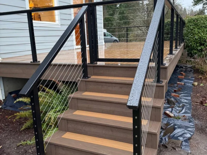 Composite deck stairs with a black metal cable railing