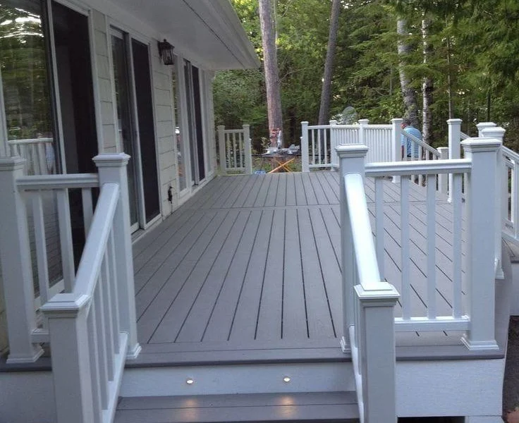 Gray composite deck with white railings and lights in the stairs