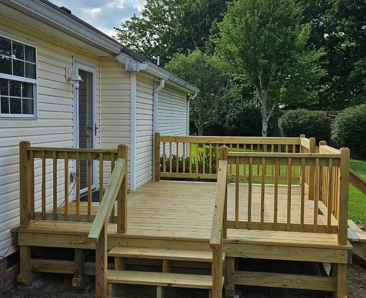 Pressure-treated deck with wood railings and steps down to the yard