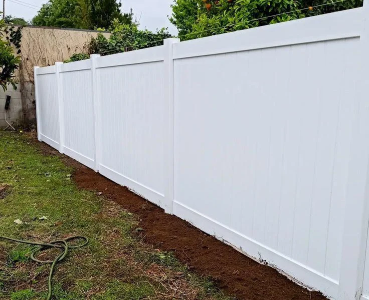 White vinyl privacy fence along a backyard