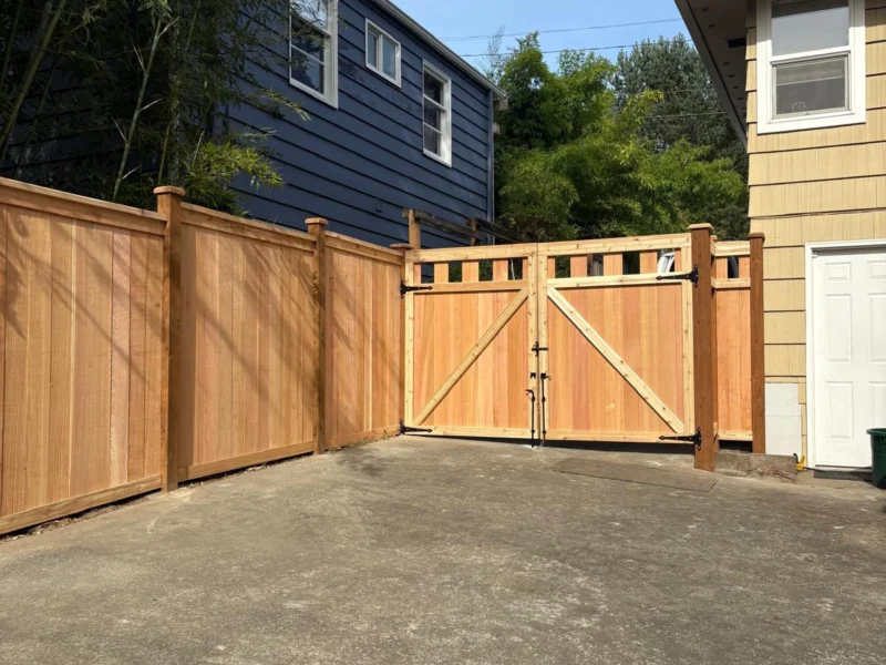 Wood privacy fence with a double gate across a driveway